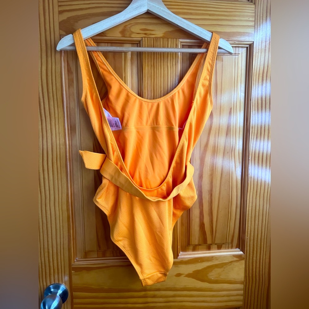 Tangerine colored bathing suit with belt accent.